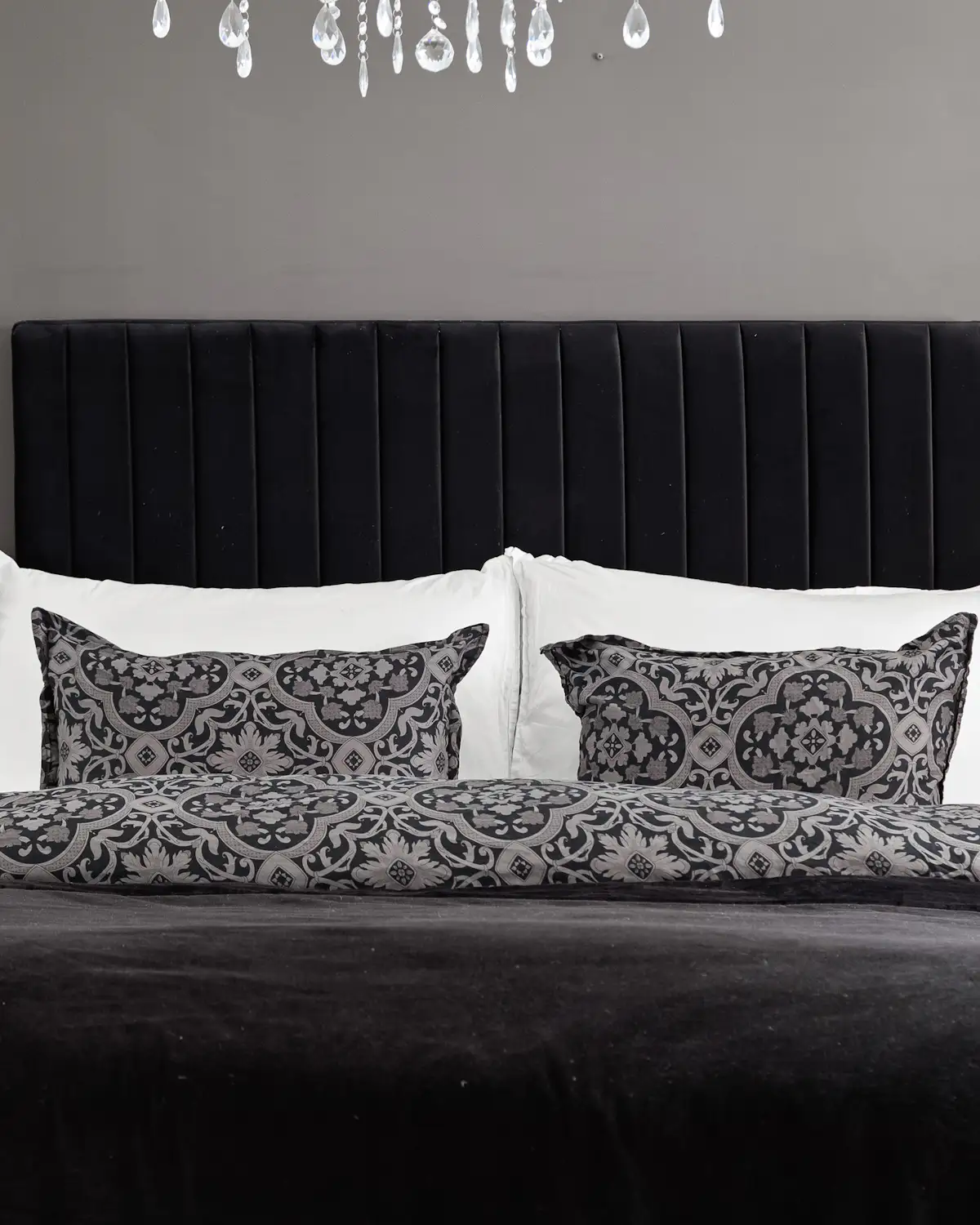 Placeholder: a monochrome bedroom interior, standing in for a monogram cut into a cushion or throw for a suite.